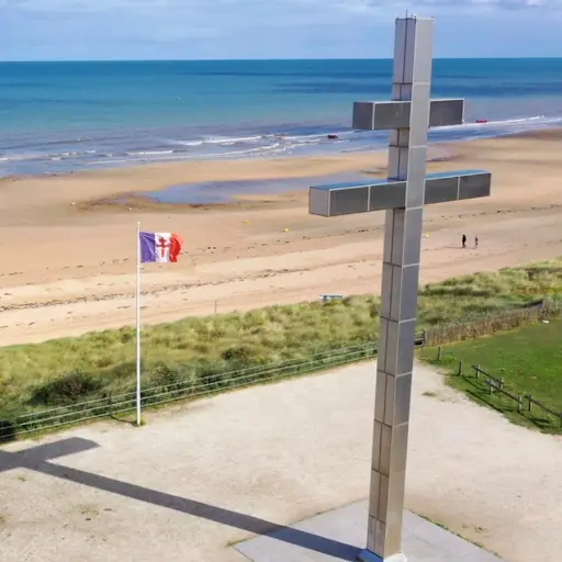 France, featuring the Cross of Lorraine memorial overlooking the sandy shoreline and English Channel.