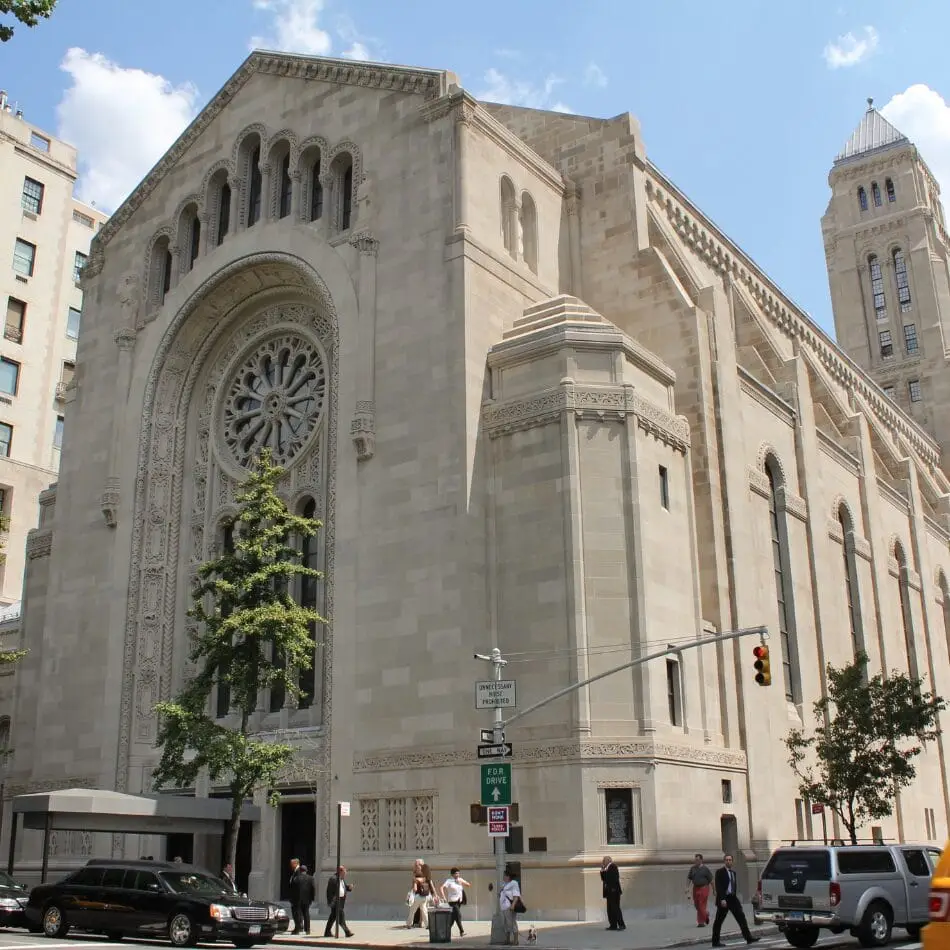 A large stone synagogue with ornate arched windows, a rose window, and a tall tower stands on a city street; people and cars are visible along the sidewalk and street under a partly cloudy sky—a scene fit for World Religions - Grade 11 (March) 2023 studies. Educational Tours | Travel for Credit | Student Travel Programs | edutravelforcredit.com | Phone: 416-923-4638 | Toll Free: 1-877-523-4638