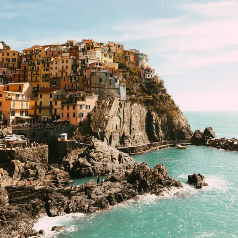 Colourful cliffside village in Cinque Terre, Italy, overlooking the rocky Ligurian coastline and turquoise sea.