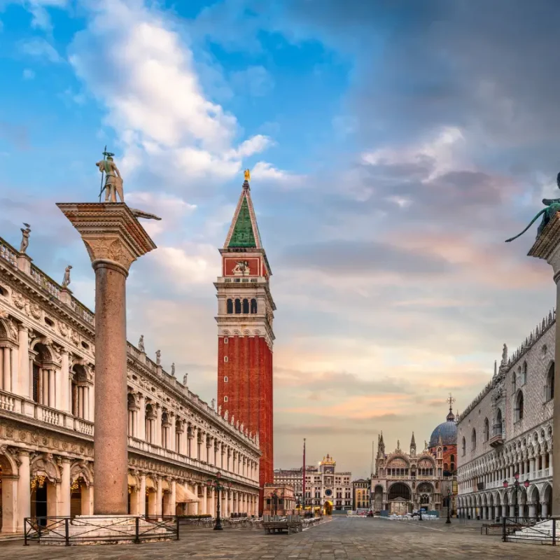 Piazza San Marco in Venice, featuring St. Mark’s Campanile, historic architecture and the open square at sunset.