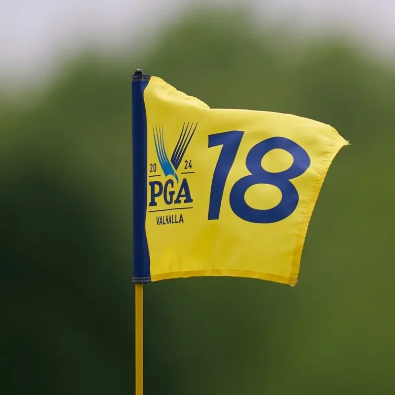 A yellow flag with a blue number 18 and the 2024 PGA Championship logo at Valhalla flutters on the course, set against a blurred green background—a striking scene reminiscent of sports in the Sunshine State. Educational Tours | Travel for Credit | Student Travel Programs | edutravelforcredit.com | Phone: 416-923-4638 | Toll Free: 1-877-523-4638